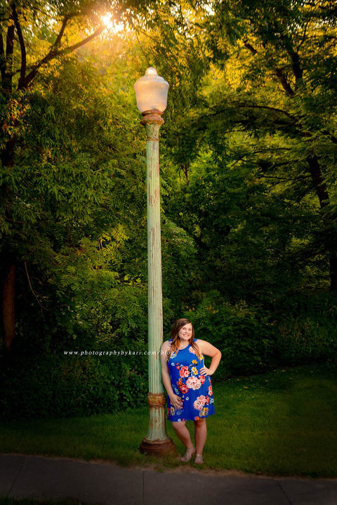 senior girl outdoors leaning on light pole