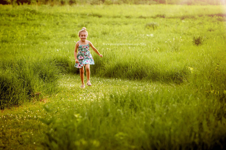 girl running in sunny green field mn portrait photographer