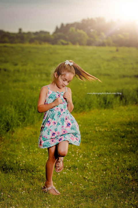 Girl wearing slower dress skipping ingreen field