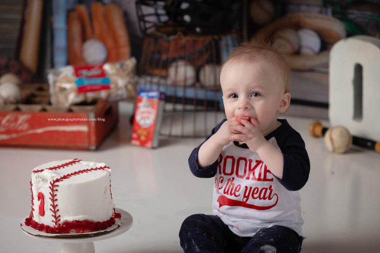 one year old baby boy eating baseball cake portrait