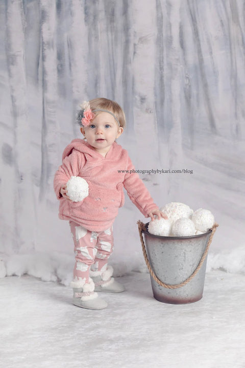 baby girl with bucket of snowballs