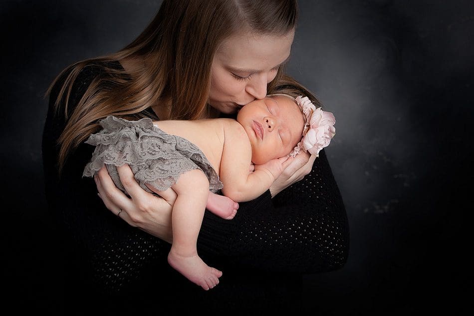 Mom kissing newborn girl