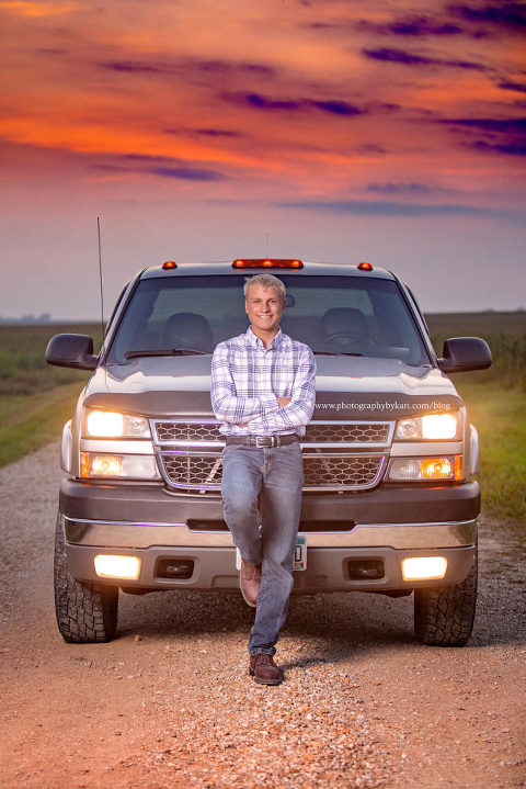 senior boy leaning on truck with beautiful sunset