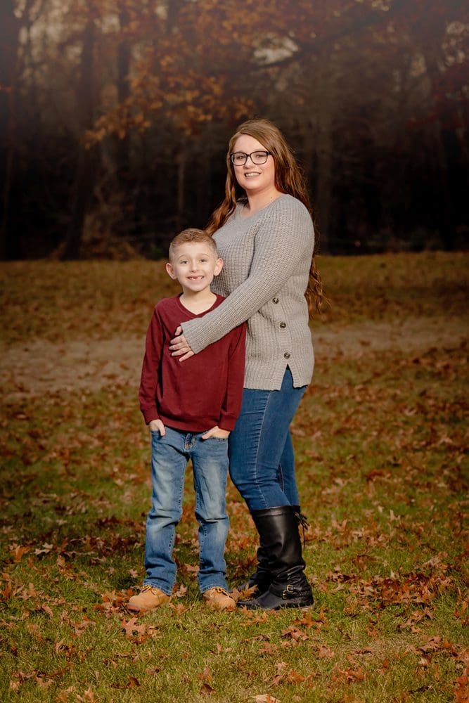Mother and Son standing in fall leaves