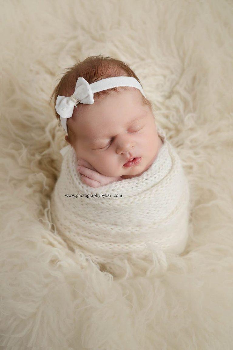 Grand Meadow Newborn girl portrait wrapped in cream