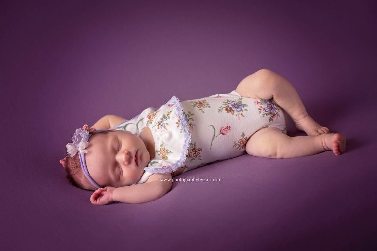 Grand Meadow Newborn girl portrait laying on purple fabric