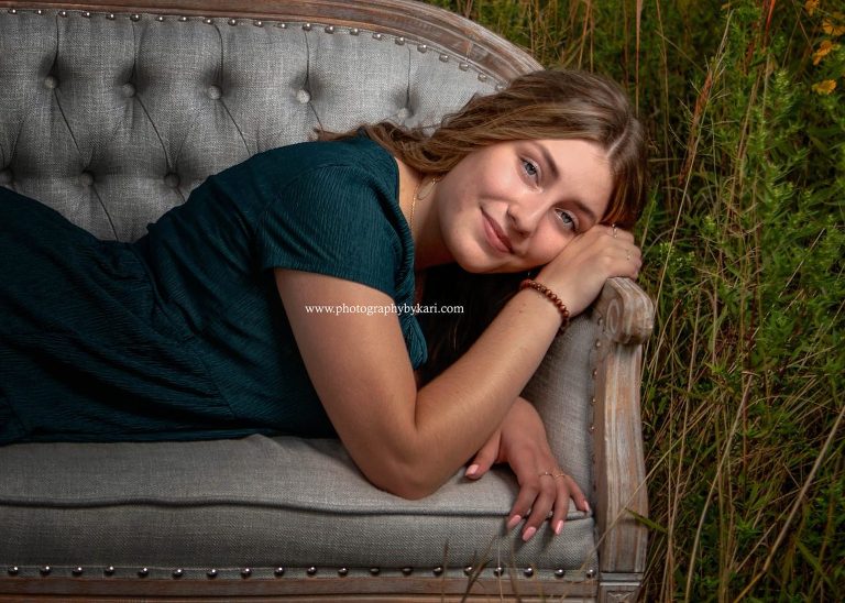 Senior girl portrait on couch in field