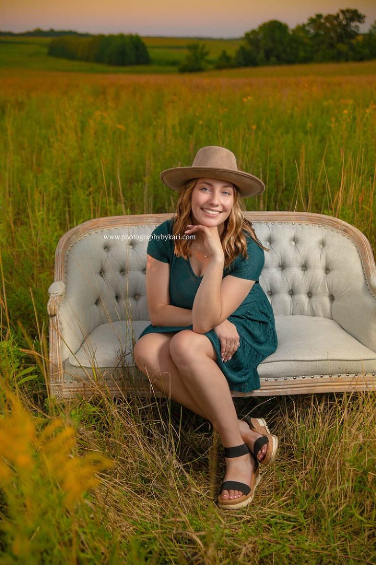 Senior girl portrait on couch in field of flowers