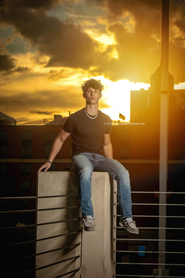 senior photo of boy taken on parking ramp with sun setting behind by Photography by Kari