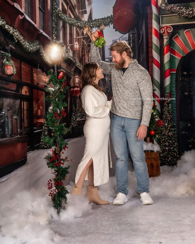 Christmas Mini session of couple with mistletoe taken in studio at Photography by Kari