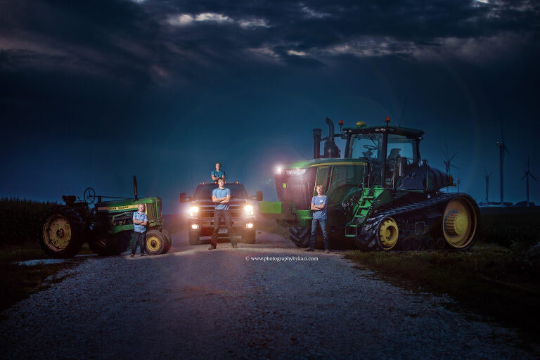Seth and his brothers posing together on a rural spring valley, mn road with their tractors and  truck for his  SE MN senior photo session
