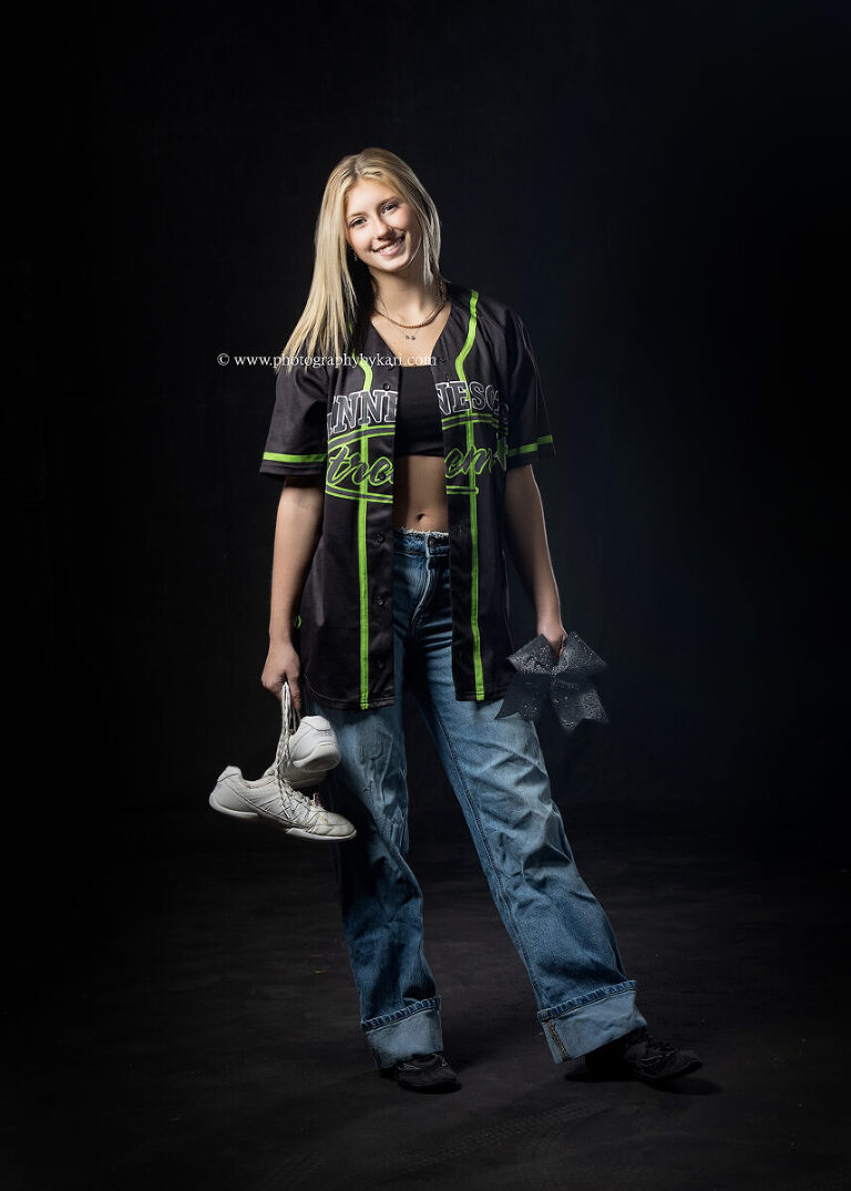 Cassie wearing Minnesota Xstreme cheer uniform in dramatic studio portrait