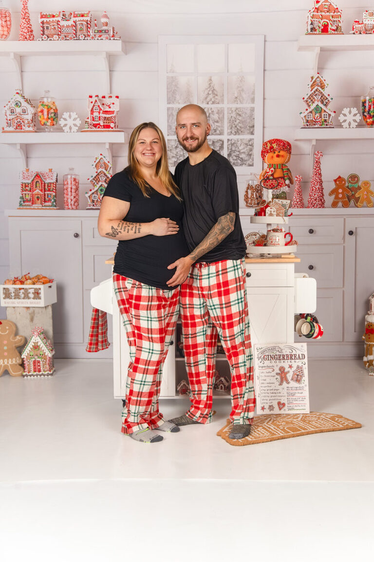 Pregnant mom with family during gingerbread baking Christmas mini photoshoot in Minnesota