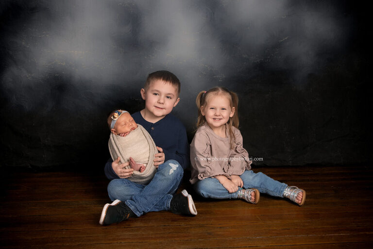 Sibling photo with newborn baby girl and older brother and sister studio portrait Spring Valley MN