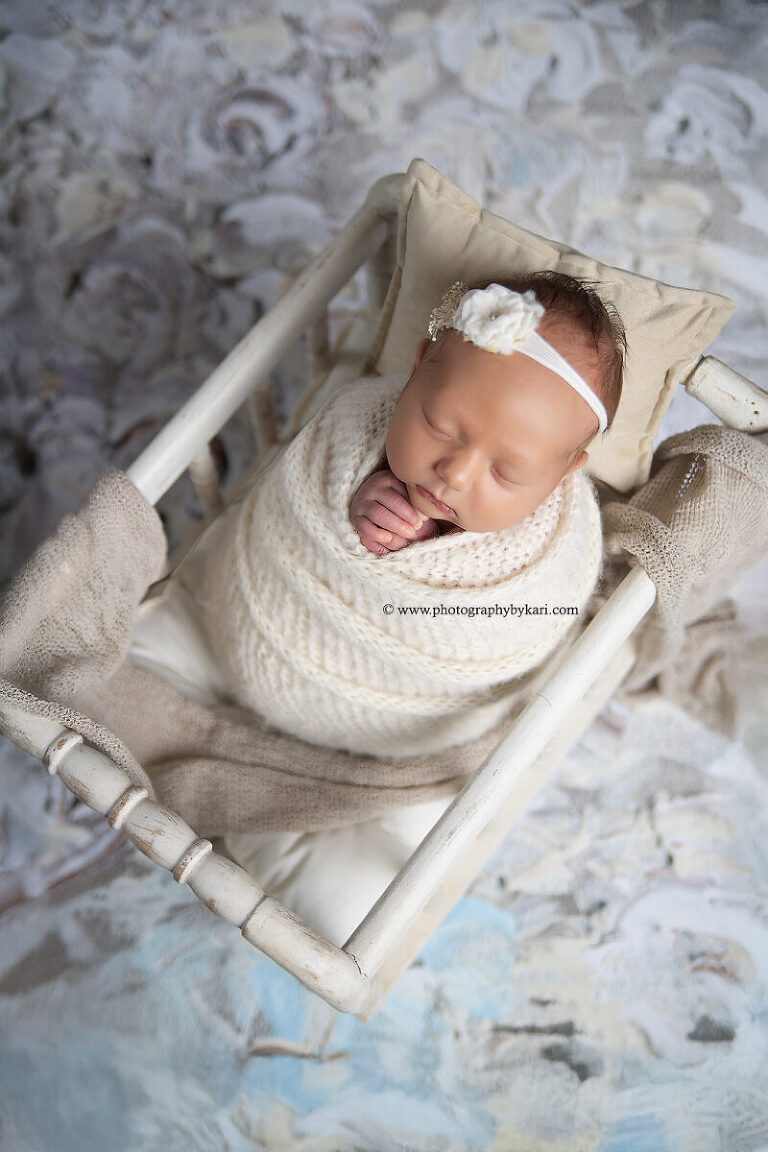 Newborn baby girl Miss V sleeping in soft neutral wrap at studio in Southeast Minnesota