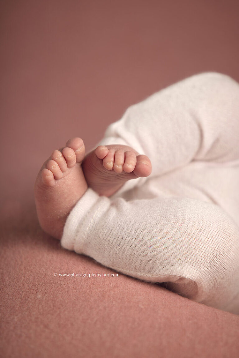 Tiny newborn baby girl detail shot of feet and toes professional portrait session