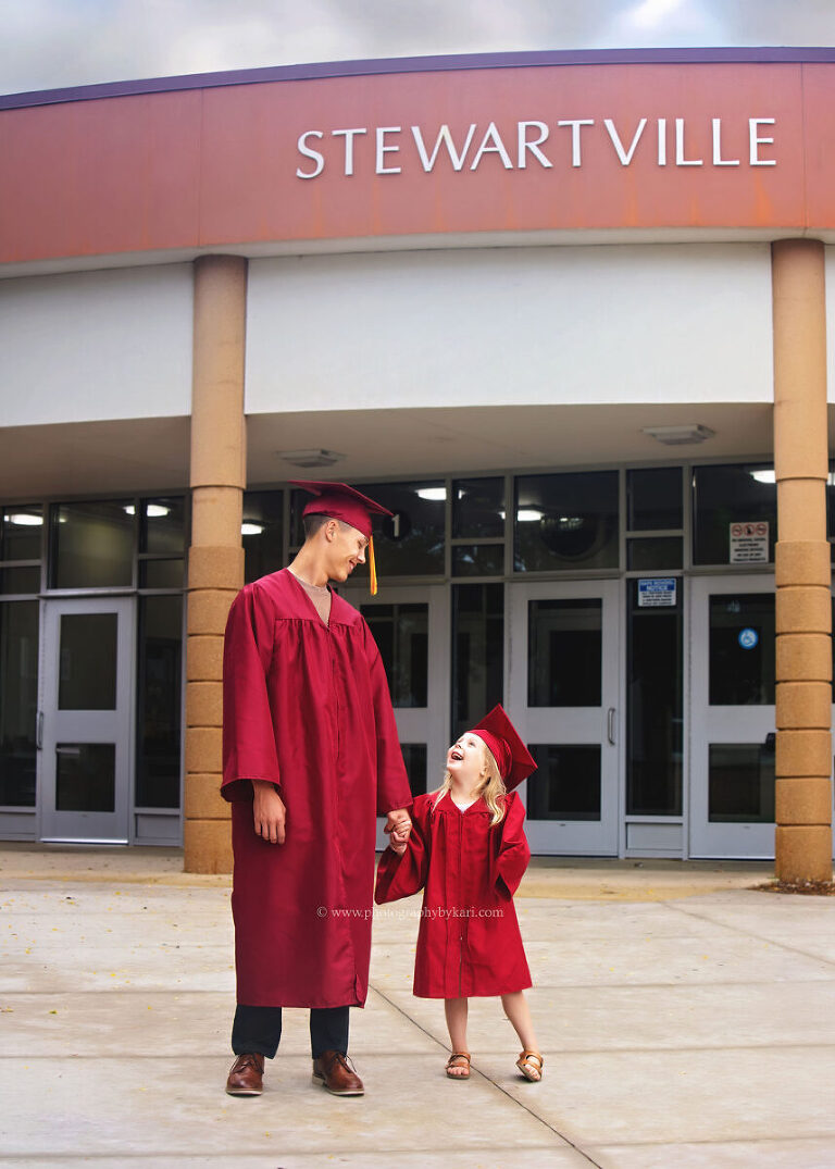 Brother and sister laughing together during graduation photo session