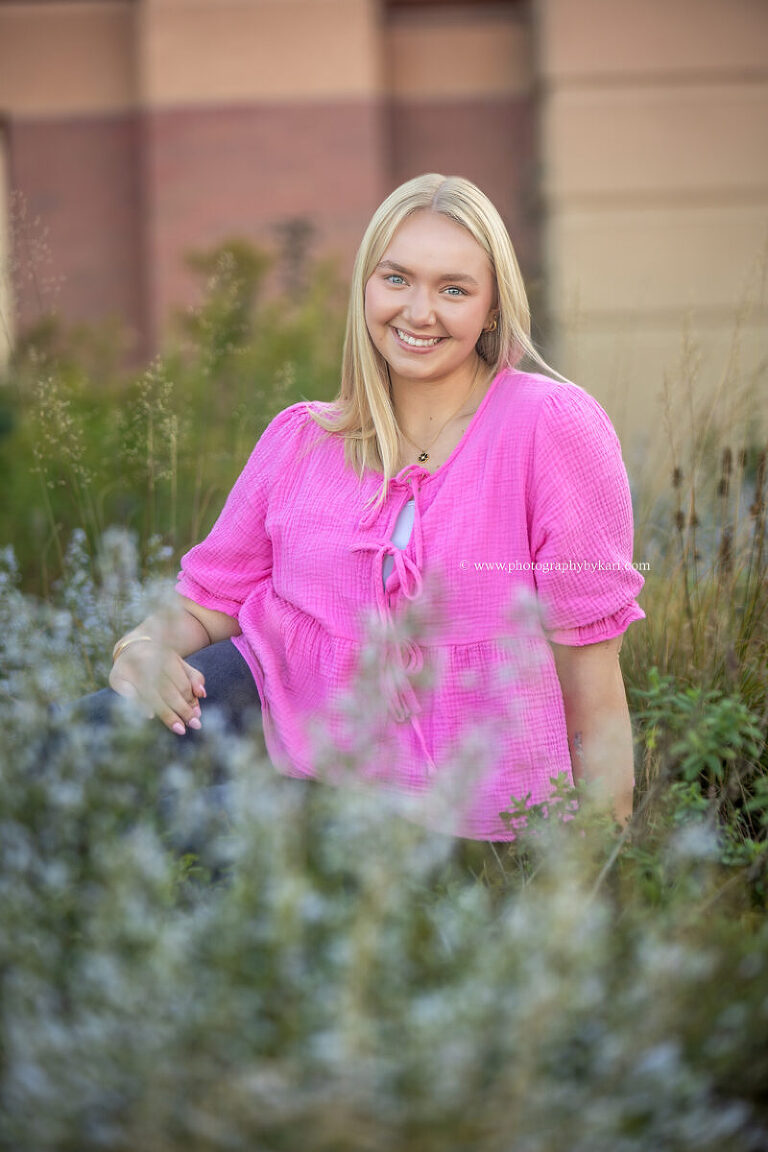 Senior girl posing near flowers during downtown Rochester session