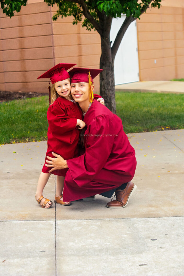 Stewartville High School Class of 2026 graduate with little sister in matching cap and gowns celebrating graduation and preschool milestones