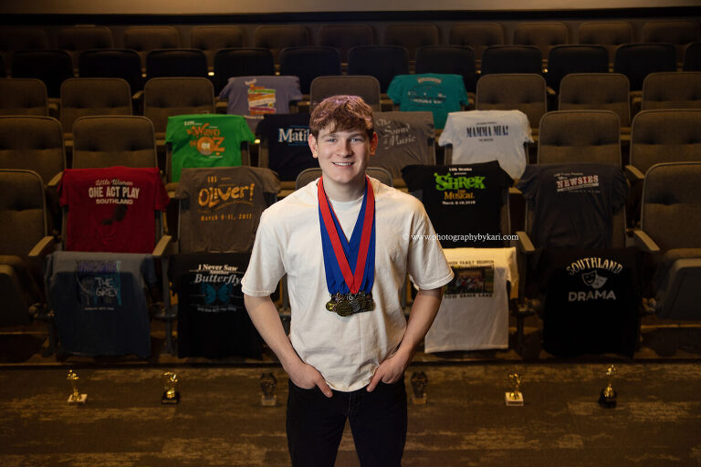Senior boy with Spring Musical shirts in theater auditorium