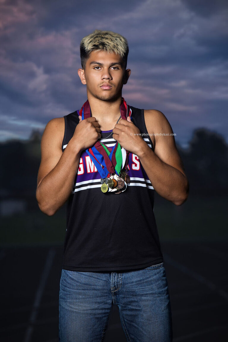 Nathaniel standing on the Grand Meadow track at sunset during his senior portrait session
